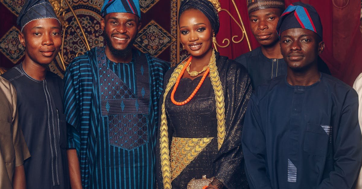 Group of adults in colorful traditional Nigerian clothing at a festive gathering.