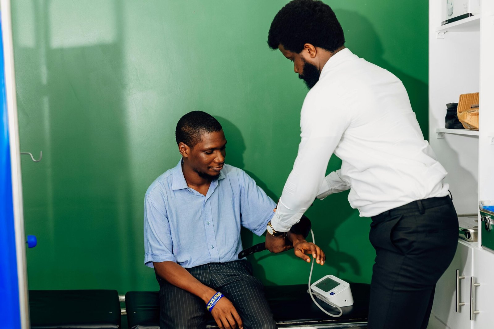 A doctor performs a blood pressure check in a Lagos clinic, emphasizing healthcare.