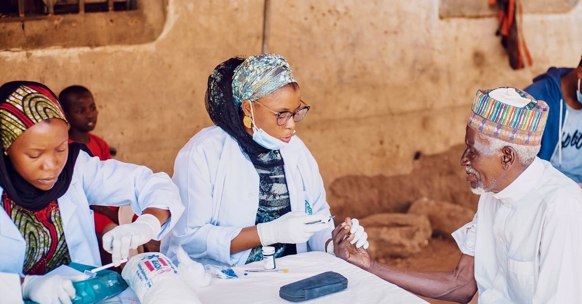 Healthcare workers assisting elderly man during community outreach in Kaduna, Nigeria.