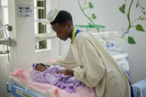 A compassionate nurse tends to a newborn in a hospital nursery, symbolizing care and dedication.