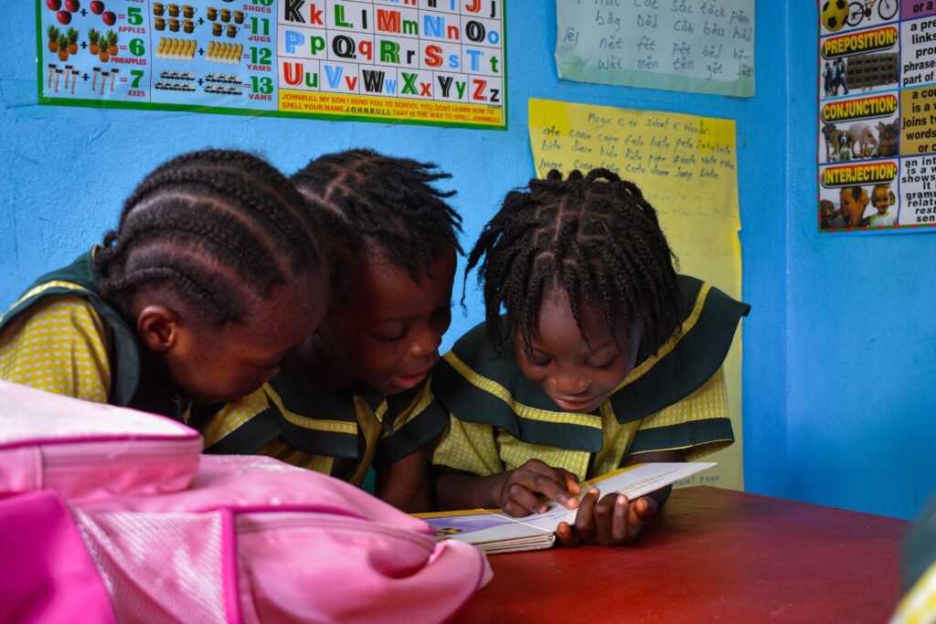 Projets Three young African girls reading at a school in Monrovia, Liberia.